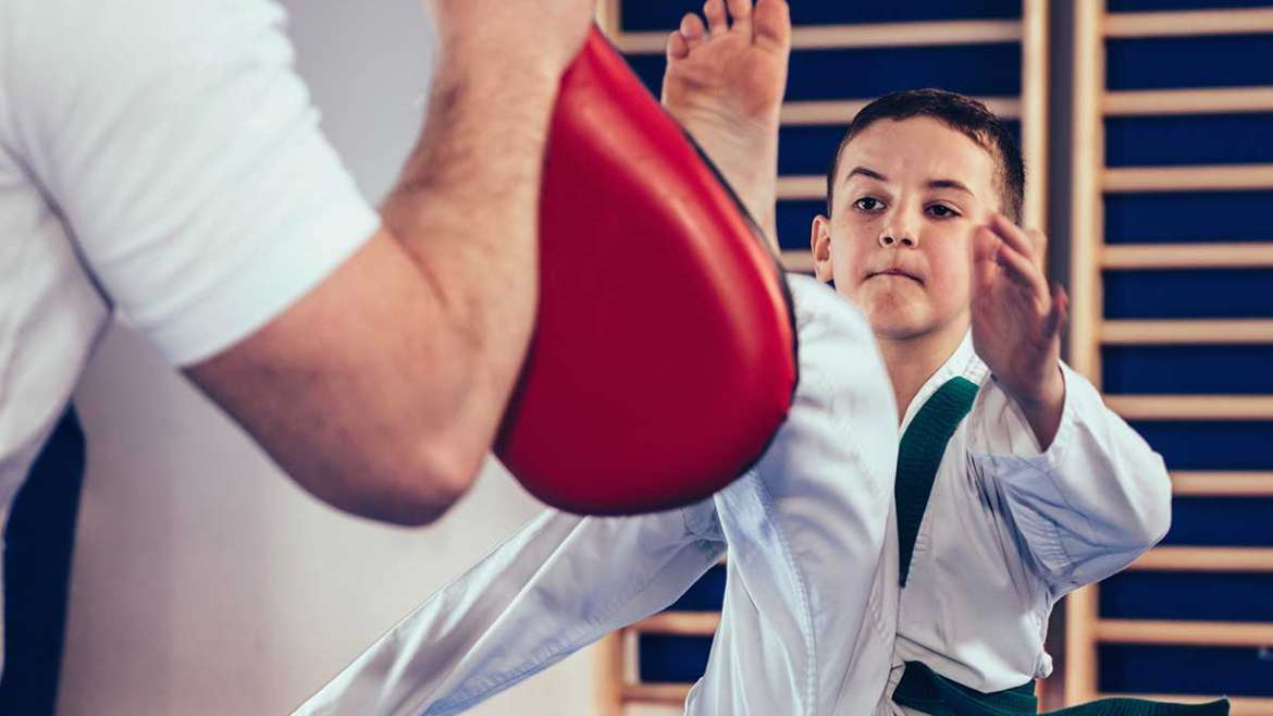 boy kicking with coach